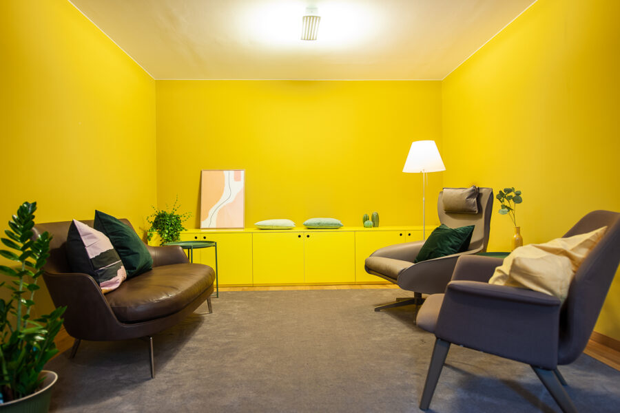 Nachsorgeberatungsraum im Blauen Haus mit modernen Möbeln und gelben Wänden