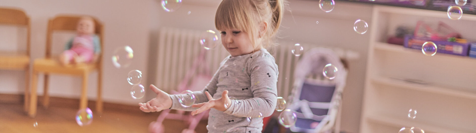 Junges Mädchen spielt in Spielzimmer mit Seifenblasen