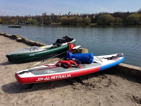Zwei Stand-Up-Paddleboards liegen am Ufer eines Sees
